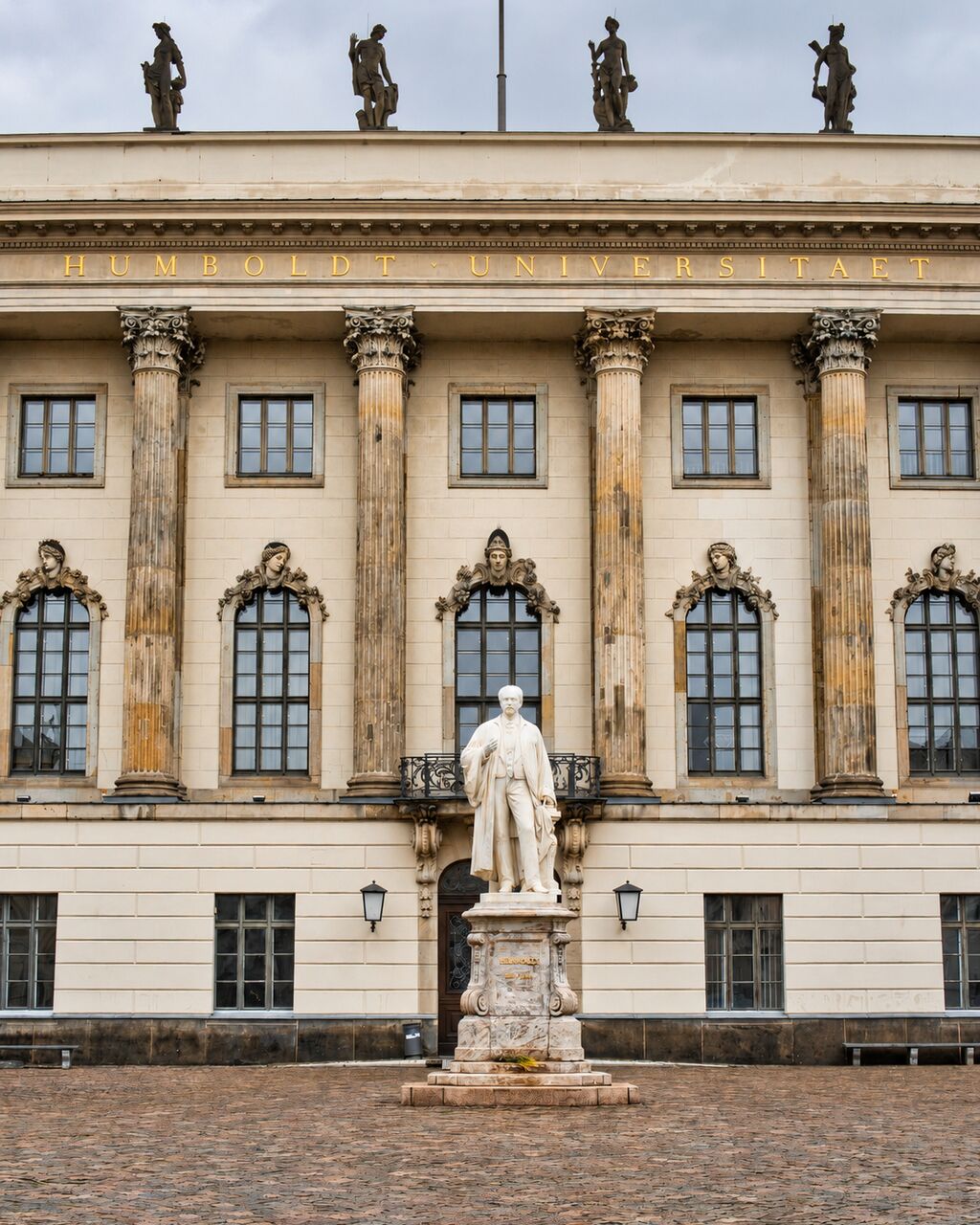 Klassizistisches Universitätsgebäude mit Säulen und Denkmal